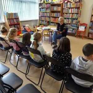 Bibliotekarka czyta dzieciom opowiadanie.