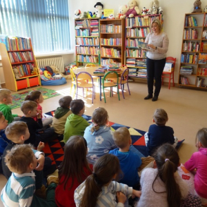 Bibliotekarka opowiada dzieciom o bibliotece. 