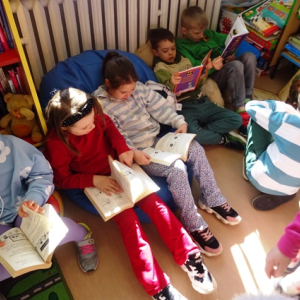Dziewczynki i chłopcy przeglądają książki.