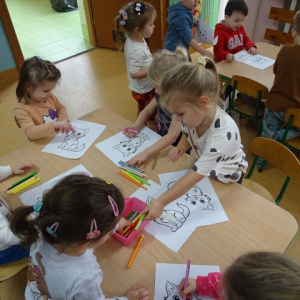Dzieci kolorują obrazki z kotami