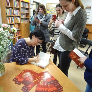 Pisarka składa pamiętkowe autografy.