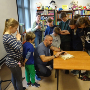 Fotograf pokazuje uczniom technikę robienia zdjęć.