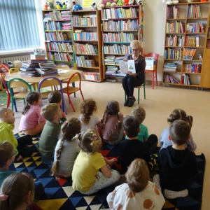 Bibliotekarka czyta przedszkolakom bajkę.