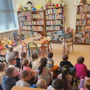 Bibliotekarka czyta  przedszkolakom opowiadanie.