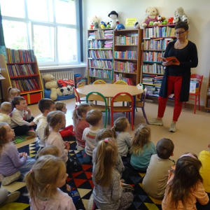 Bibliotekarka czyta dzieciom książkę z serii "Czytam sobie"