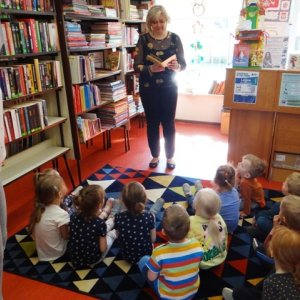 Bibliotekarka czyta dzieciom książeczkę.