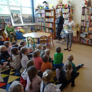 Bibliotekarka czyta przedszkolakom bajkę.