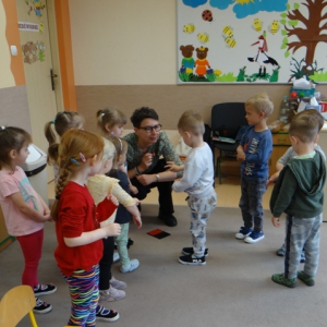 Bibliotekarka stempluje rączkę dziecka.