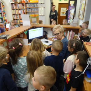 Bibliotekarka pokazuje stanowisko obsługi czytelników.