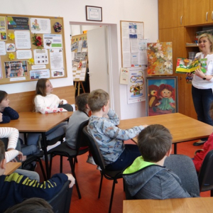 Bibliotekarka pokazuje dzieciom książkę.