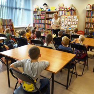 Przedszkolaki rozmawiają z bibliotekarką o jesieni.