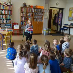 Pani bibliotekarka pokazuje dzieciom różne książki