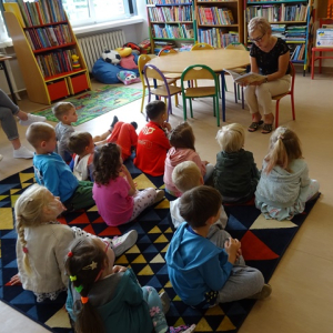 Bibliotekarka czyta dzieciom opowiadanie.