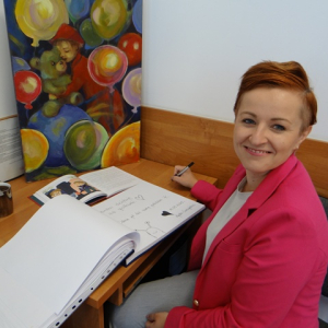 Agata Cieszyńska wpisuje się do księgi pamiątkowej 