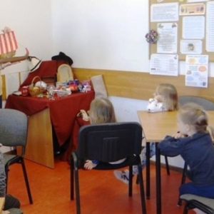 Bibliotekarka pokazuje statek piracki jako symbol bajki dla dzieci 
