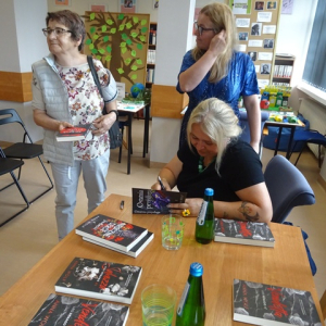 Autorka składa autografy w książkach