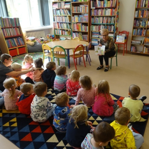 Bibliotekarka pokazuje przedszkolakom ilustracje w książce