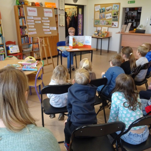 Dzieci słuchają legendy oglądając plansze teatrzyku