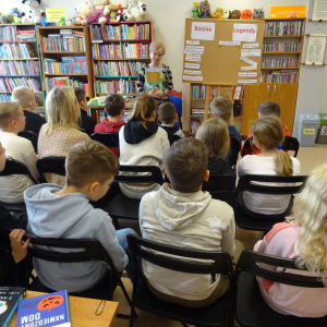 Bibliotekarka pokazuje dzieciom książkę z legendami