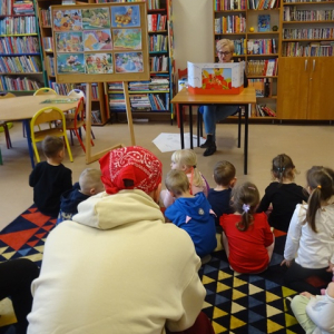 Dzieci oglądają teatrzyk planszowy i słuchają bajki 