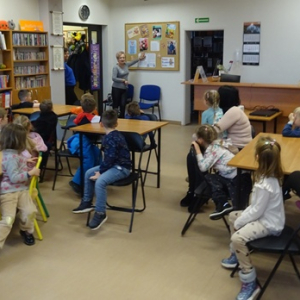 Bibliotekarka pokazuje przedszkolakom ilustracje z misiami z bajek