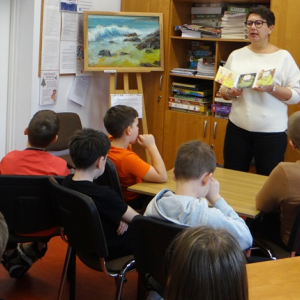 Bibliotekarka pokazuje uczniom audiobook