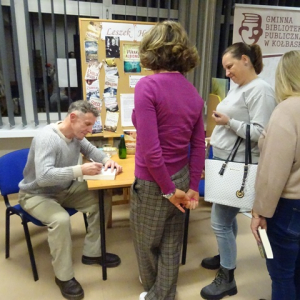 Leszek Herman wpisuje czytelnikom dedykacje do książek