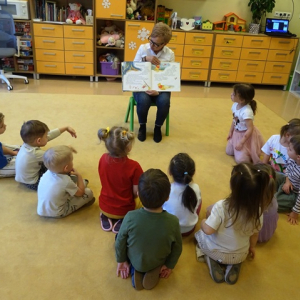 Bibliotekarka pokazuje przedszkolakom ilustrację z książki