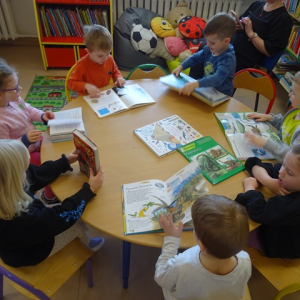 "Żyrafy" oglądają książeczki o dinozaurach