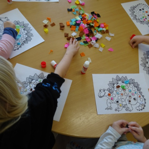 Dzieci wyklejają dinowaury kolorowymi karteczkamiprzyklejają