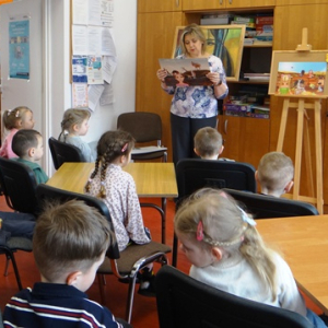 Przedszkolaki słuchają opowiadania i oglądają kolorowe plansze