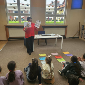 Dyrektor pokazuje uczniom plansze z polskimi banknotami i monetami