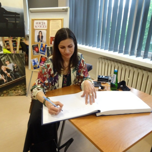 Alicja Sinicka wpisuje się do Księgi Pamiątkowej