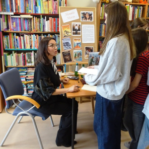 Aurotka daje uczniom pamiątkowe karty z dedykacją i autografem