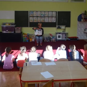 Bibliotekarka czyta dzieciom bajkę.