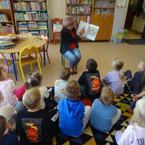 Bibliotekarka czyta tekst, a dzieci odgadują umieszczone ilustracje