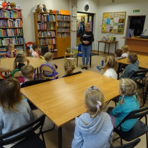 Bibliotekarka czyta dzieciom opowiadanie.