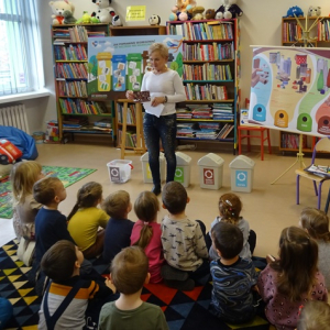 Bibliotekarka pyta dzieci do którego śmietnika należy wrzucić liście.