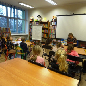 Bibliotekarka czyta uczniom opowiadanie.